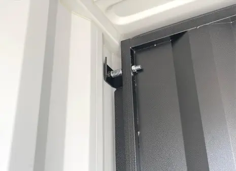 Close-up of the pressure point fixing mechanism for a removable bulkhead inside a shipping container.