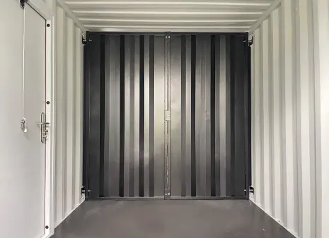 Interior of a standard shipping container with a removable bulkhead partition.