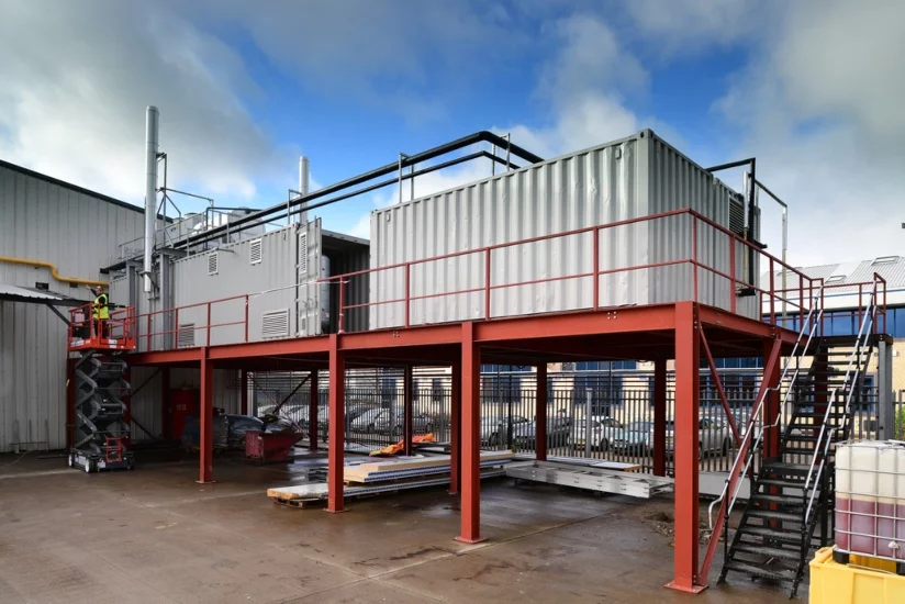 Grey Containers Suspended on Red Platform