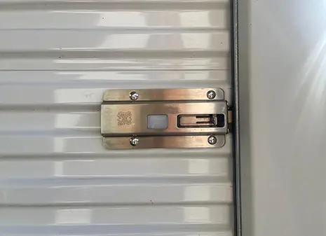 Fingerprint-compatible lock mechanism on a roller shutter topper storage unit door.